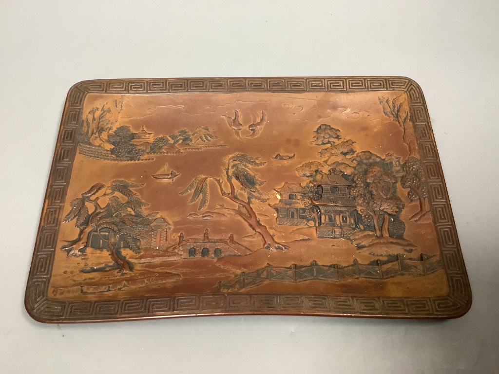 A Chinese carved hardstone pendant, a carved coral Guanyin, an engraved nut pendant, and a lacquered tray